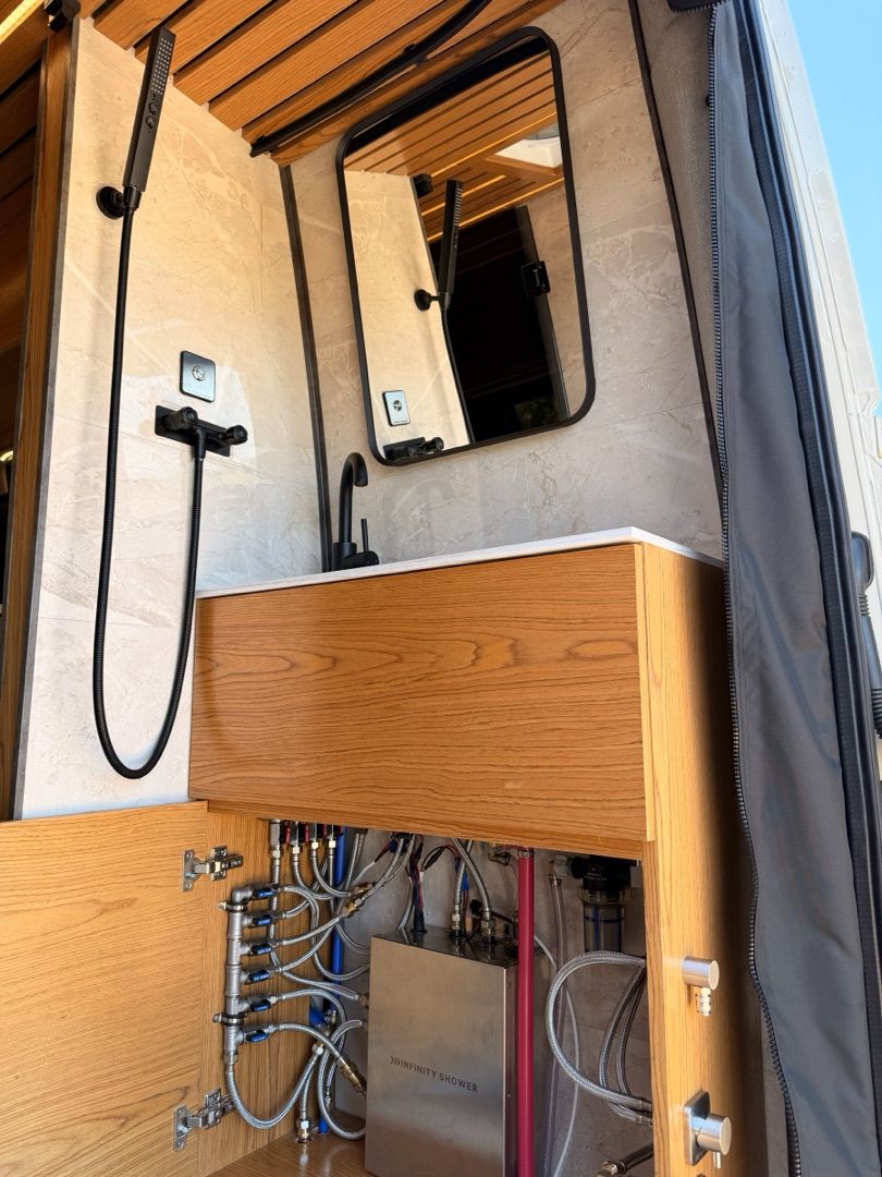 A van shower with wood slat walls and black fixtures