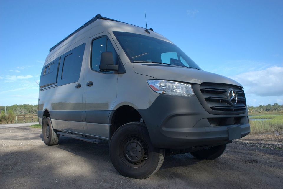 A gray Drifter on a gravel lot with its black wheels and roof rack