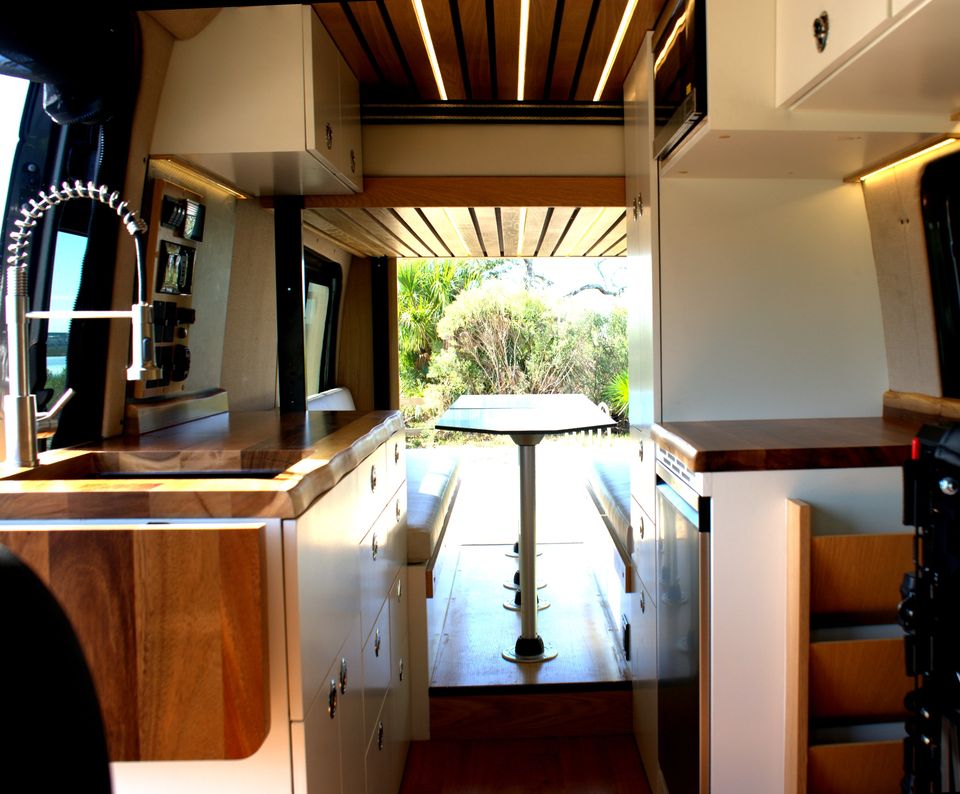 A walnut slat ceiling and pull-down faucet over the galley