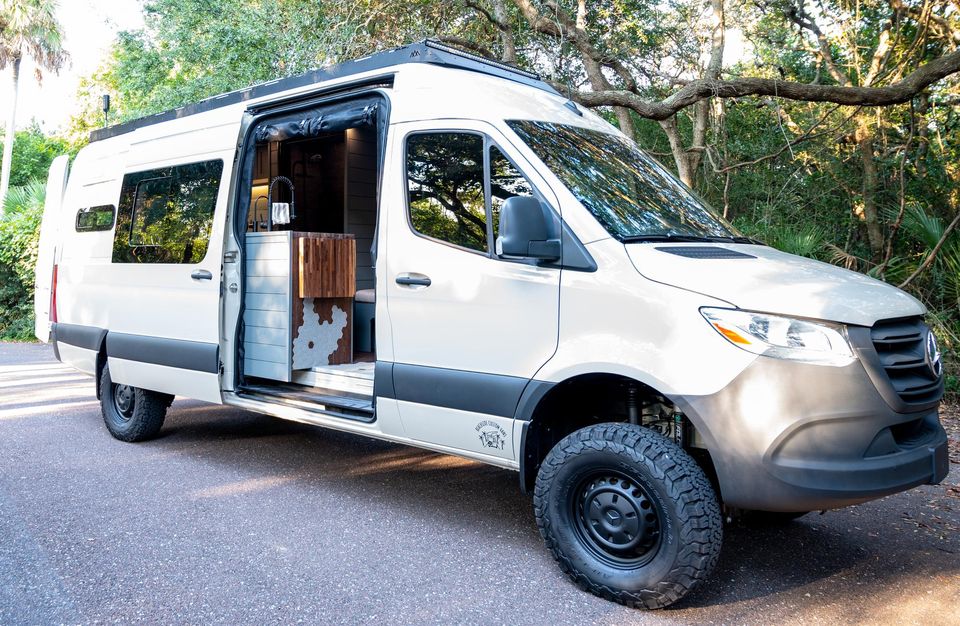 A gray Sprinter with a front bumper, winch and racing stripes