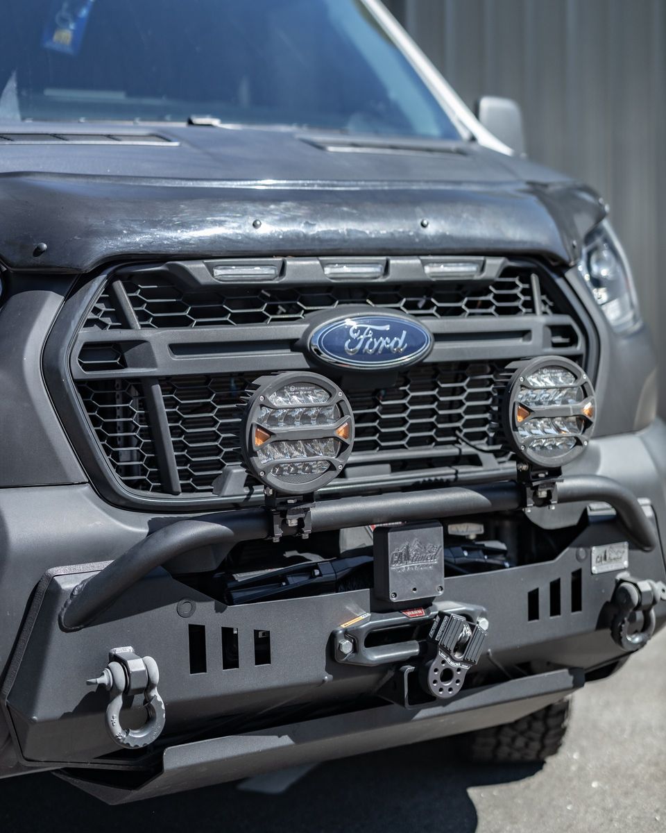 The front of a custom Ford Transit with auxiliary lights