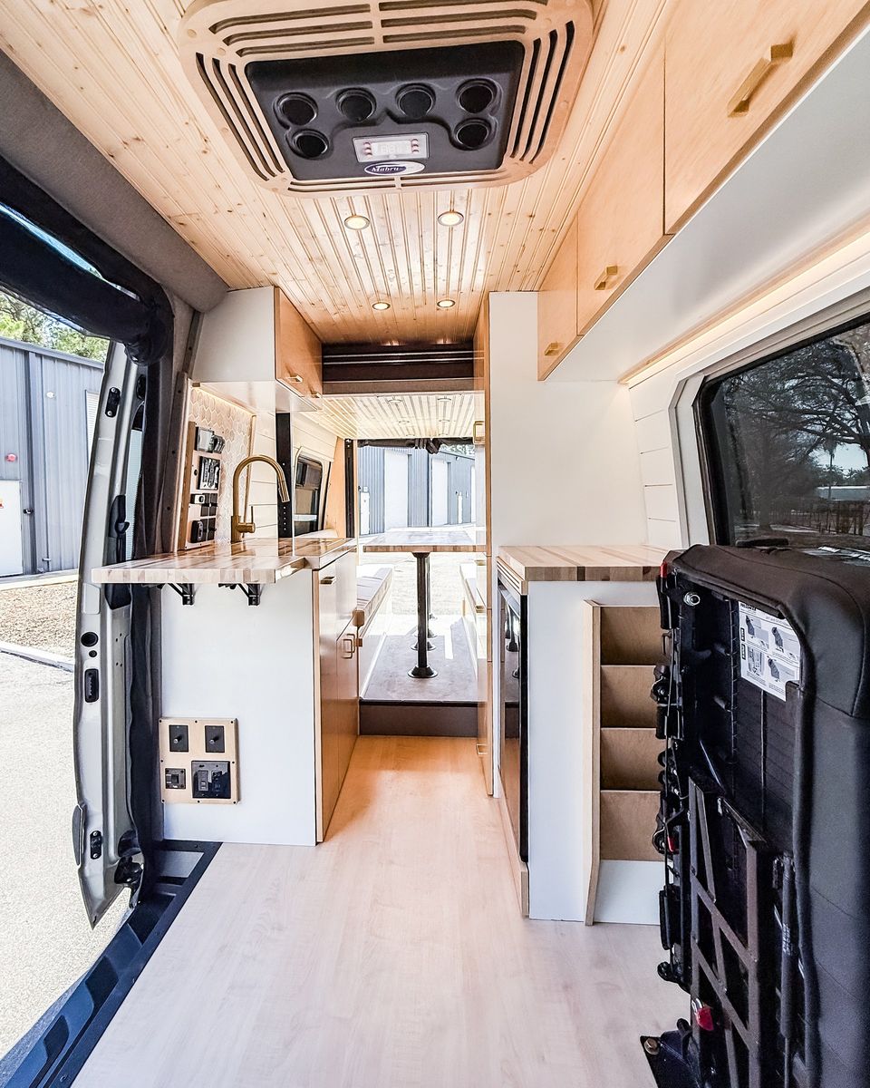 A light wood galley with a stainless fridge