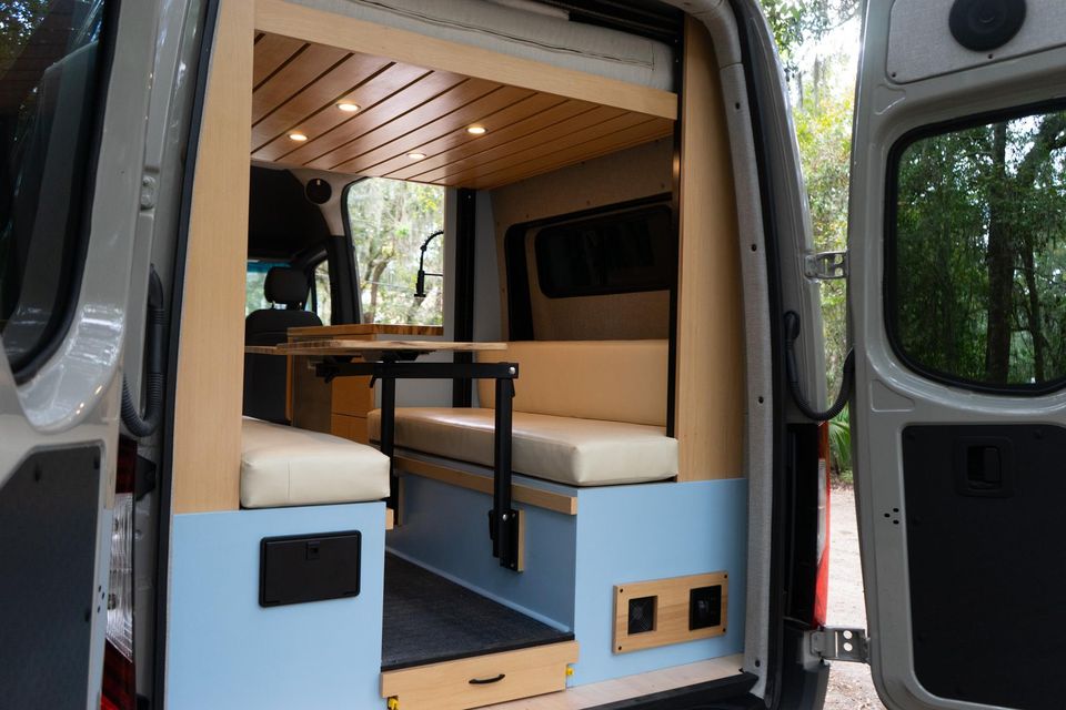 A dinette with cushioned seats inside a custom van