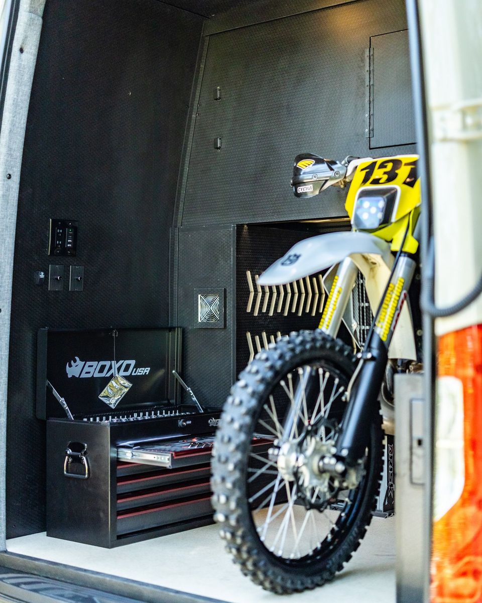 A dirt bike loaded in the gear garage of a Sprinter