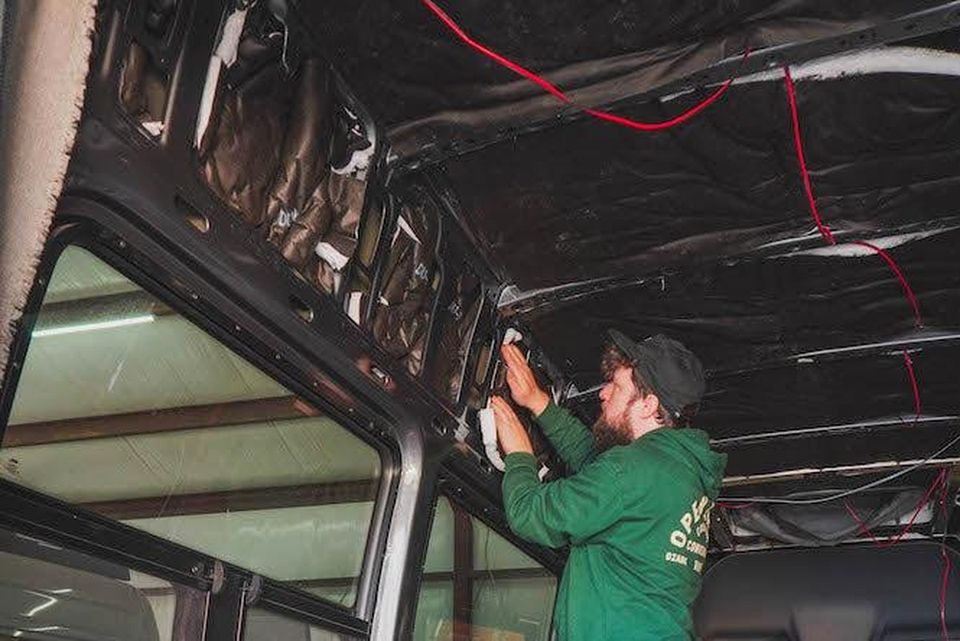 A Beachside technician installing insulation inside a van