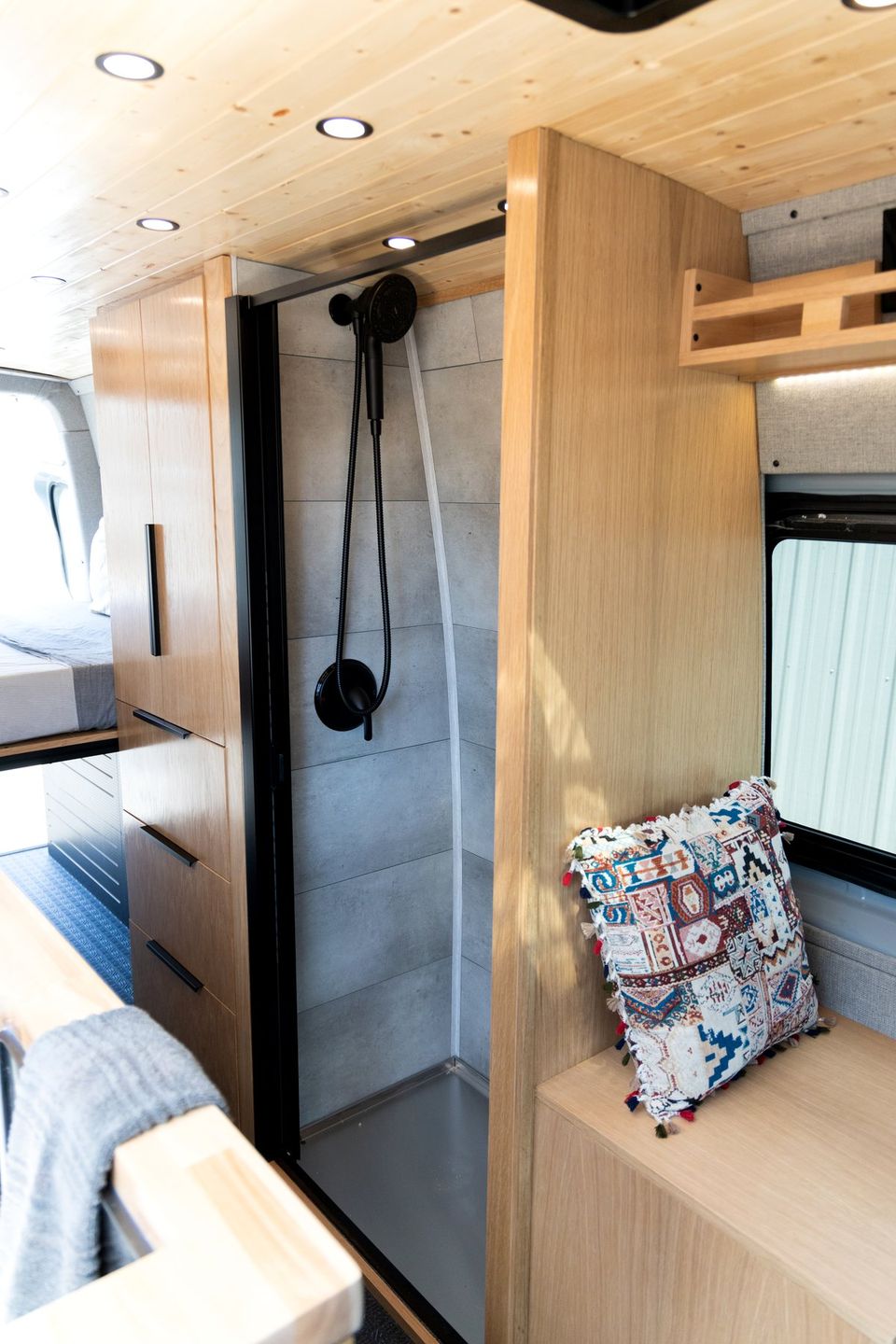 A van shower with wood slat walls and black fixtures